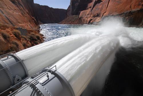 The spillway tubes of the Hoover dam are opened, sending out two massive jets of water.
